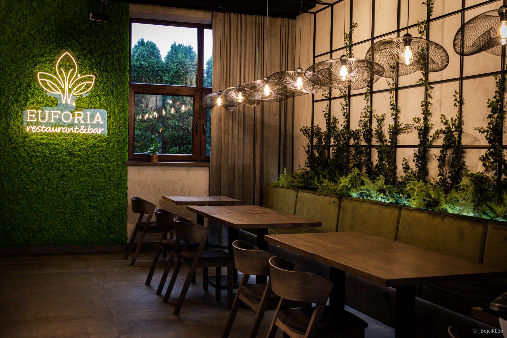 Wnętrze restauracji Euforia w Myślenicach z neonowym logo i zieloną ścianą