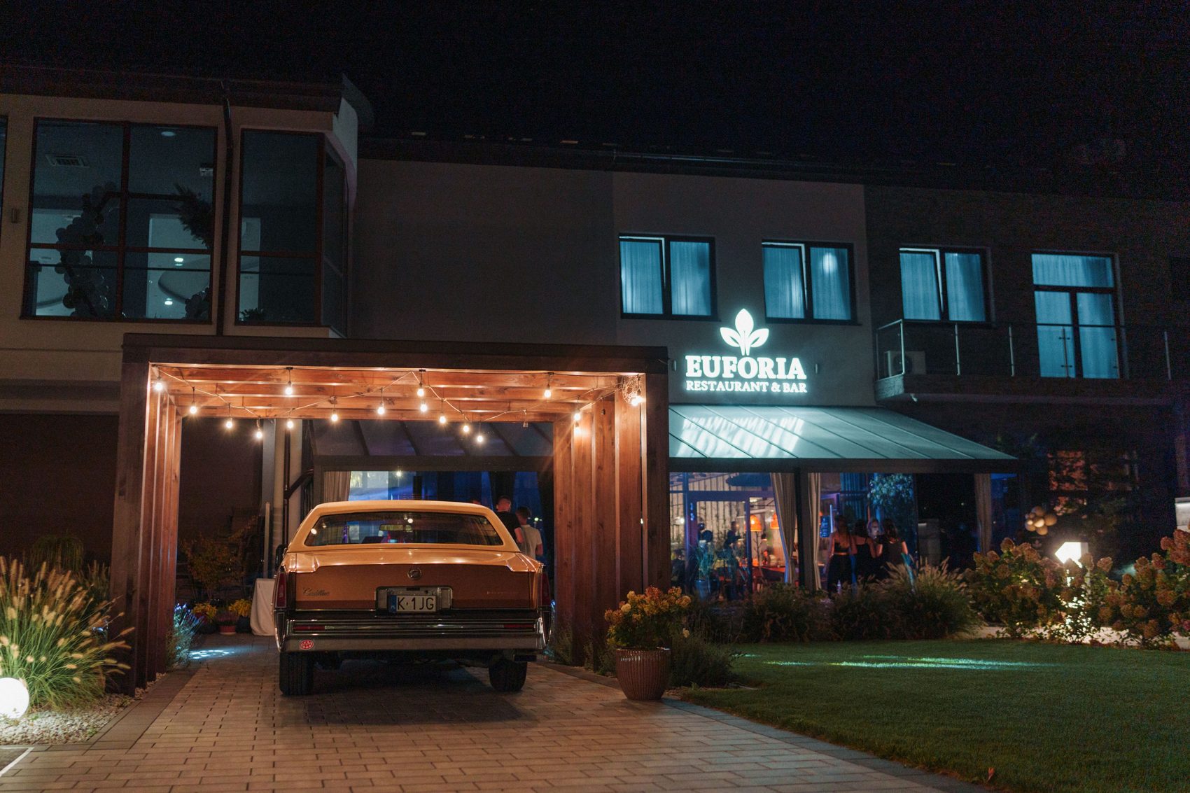 Wejście do restauracji Euforia w Myślenicach i parking dla gości wieczorem